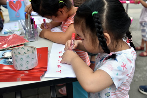 与社区内儿童通过填图反邪教色卡活动向家长宣传反邪教知识